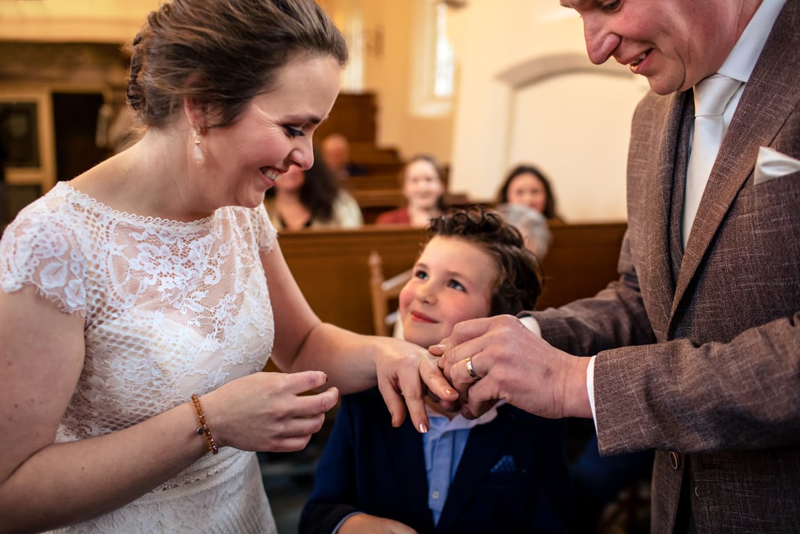 Ringen omdoen met bruidsjonker door trouwfotografie Alblasserdam