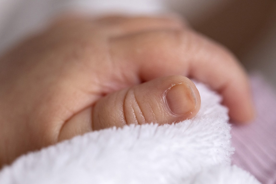 Newbornreportage met details van het handje